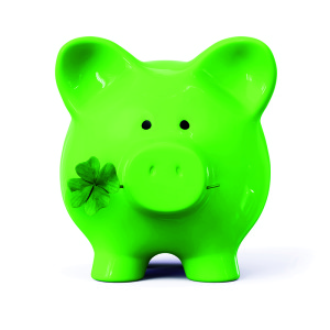 Green piggy bank with four leaf clover